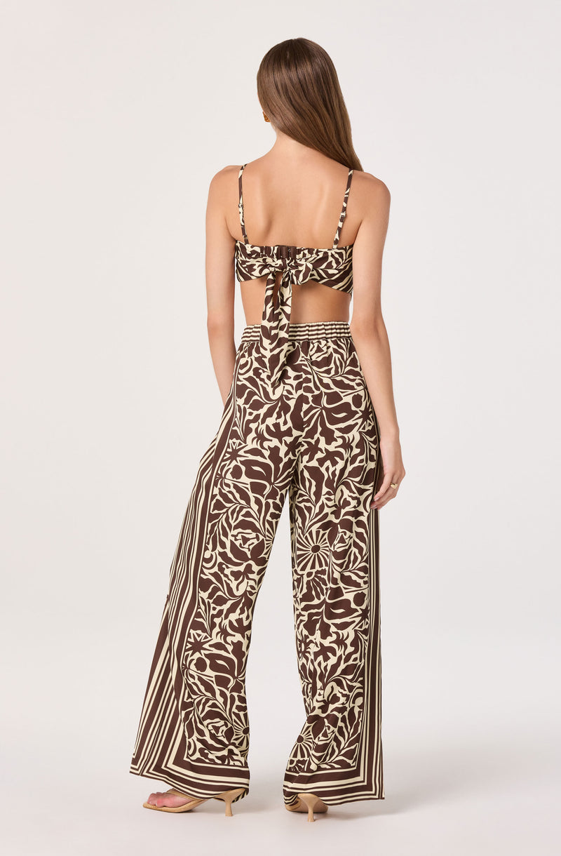 Two-piece printed outfit with a crop top and wide-leg pants, in brown and cream floral and stripe patterns.