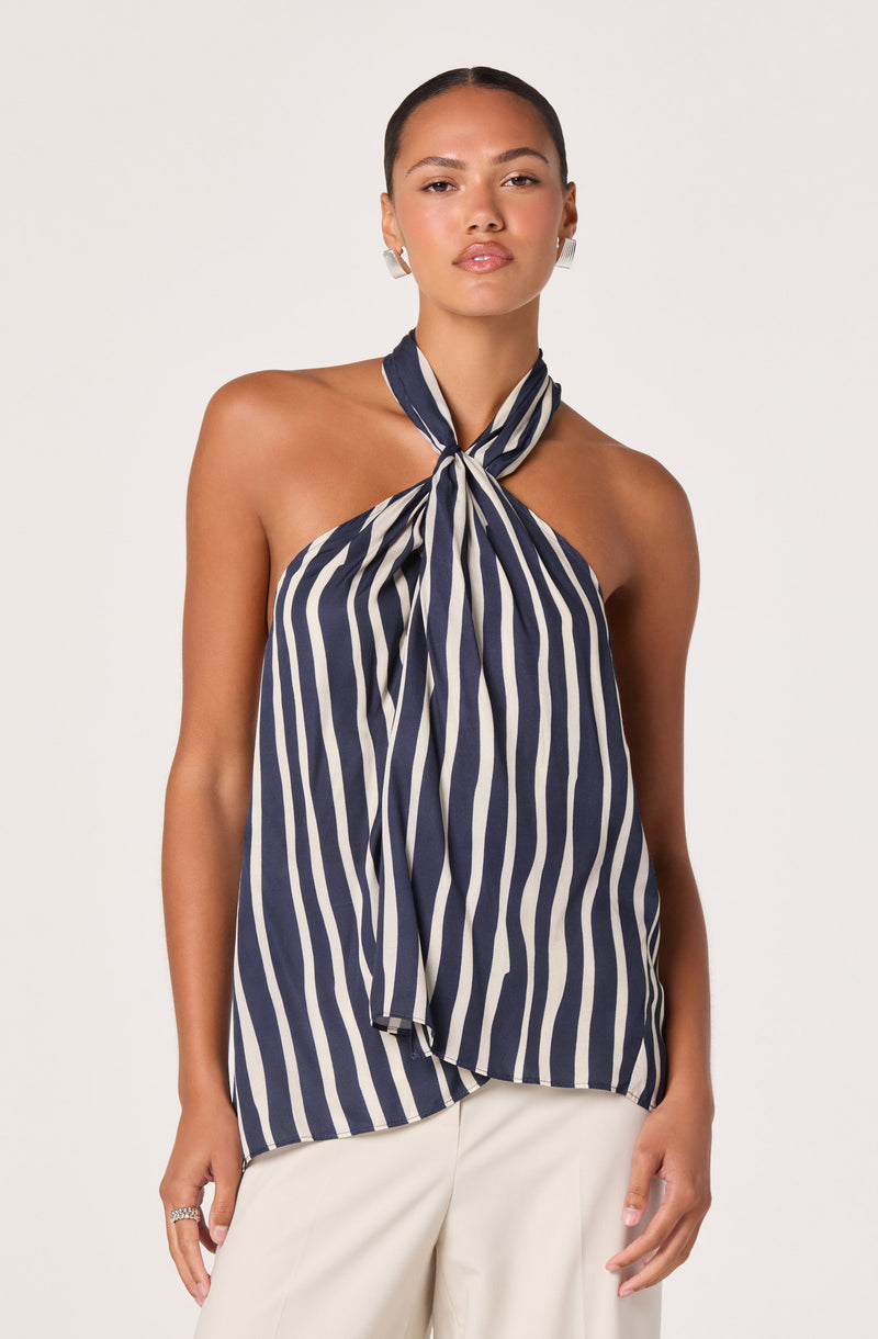 Woman wearing a navy and white striped halter top with a bow knot at the neck.