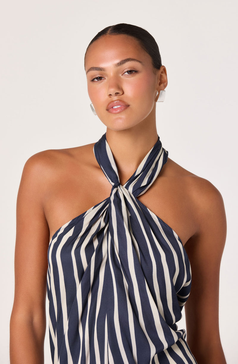 Woman wearing a strapless navy and white striped top with a matching neck scarf.