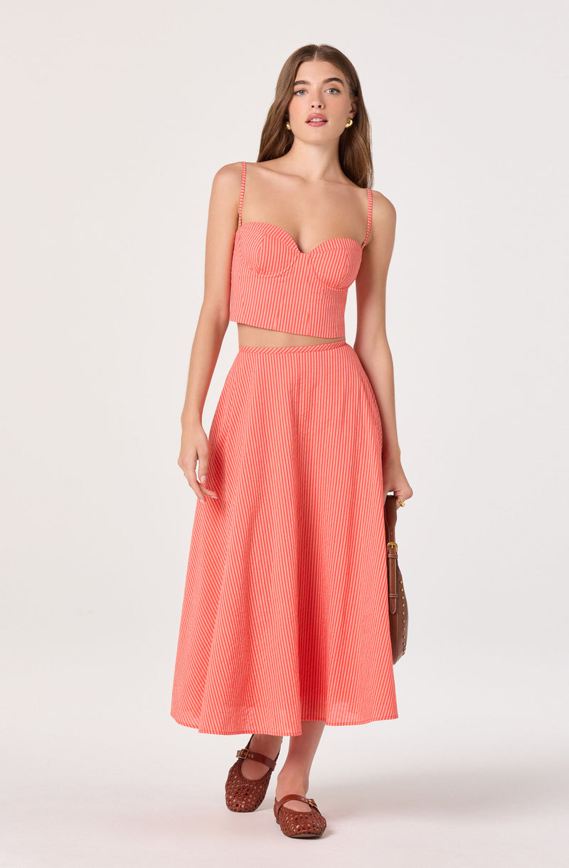 Coral and white striped crop top with spaghetti straps, matching wide-leg pants, and brown woven shoes.