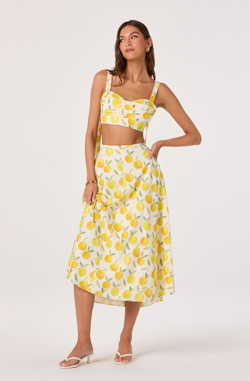 Two-piece dress with a lemon print: crop top with thick straps and a high-waisted, flowy skirt.