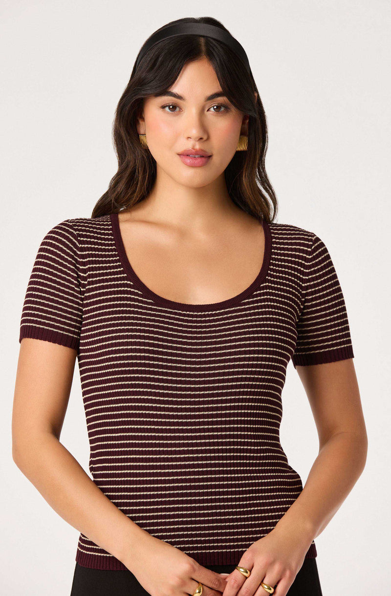 Woman wearing a maroon and beige striped short-sleeve knit top.
