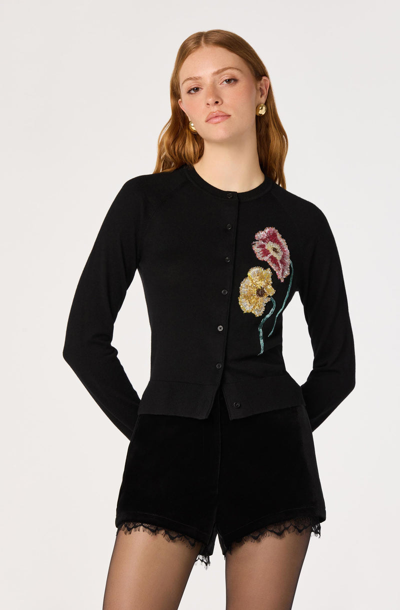 Black cardigan with embroidered pink and yellow flowers, paired with black shorts with lace trim.