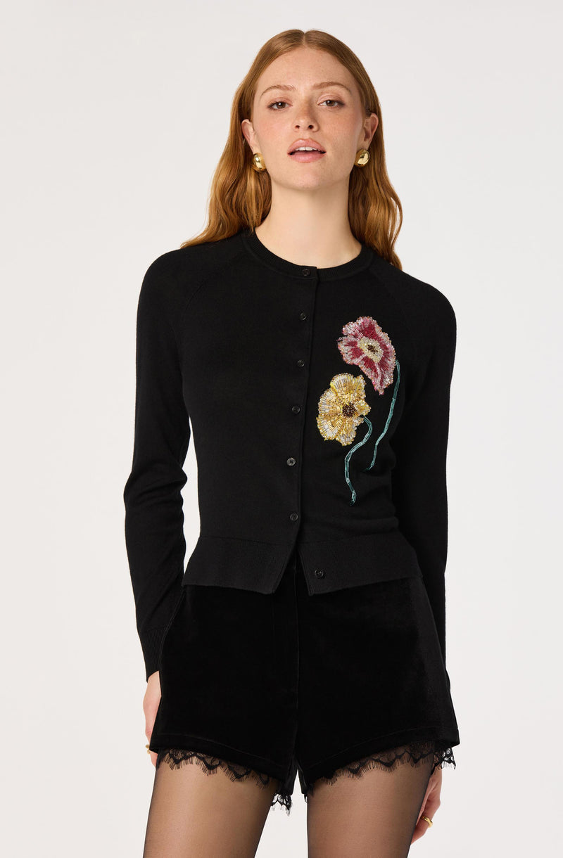 Black cardigan with floral embroidery, paired with black shorts and sheer tights.