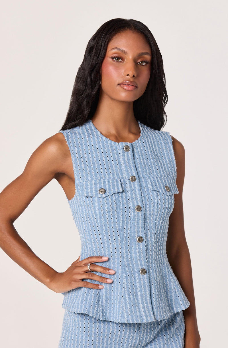 Sleeveless light blue textured dress with silver buttons and front flap pockets.