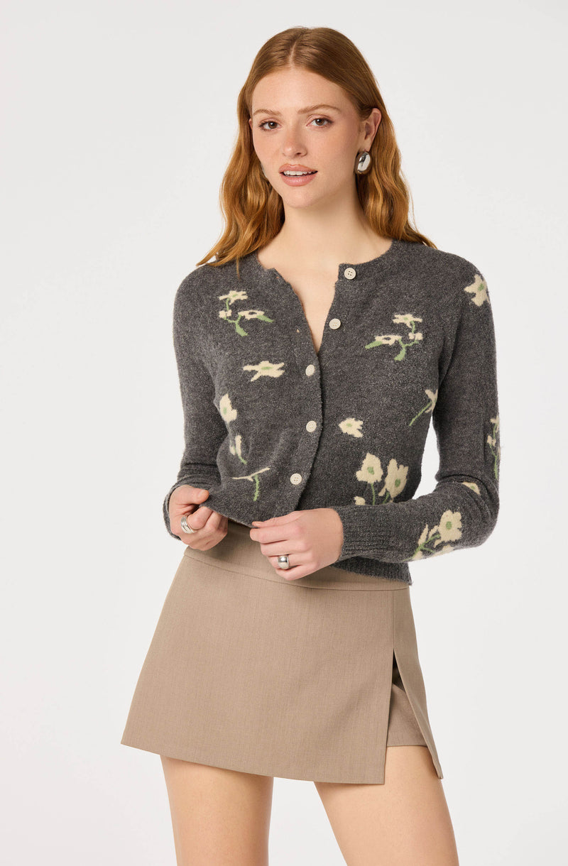 Gray cardigan with white floral print and white buttons, paired with a beige skirt.