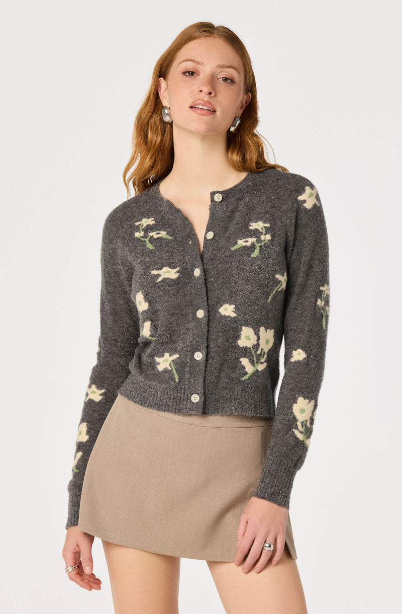 Women's gray cardigan with a floral pattern and beige buttons, paired with a beige skirt.