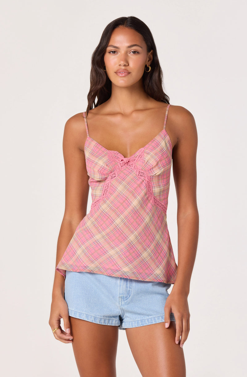 Woman wearing a pink plaid spaghetti strap top with ruffle details.