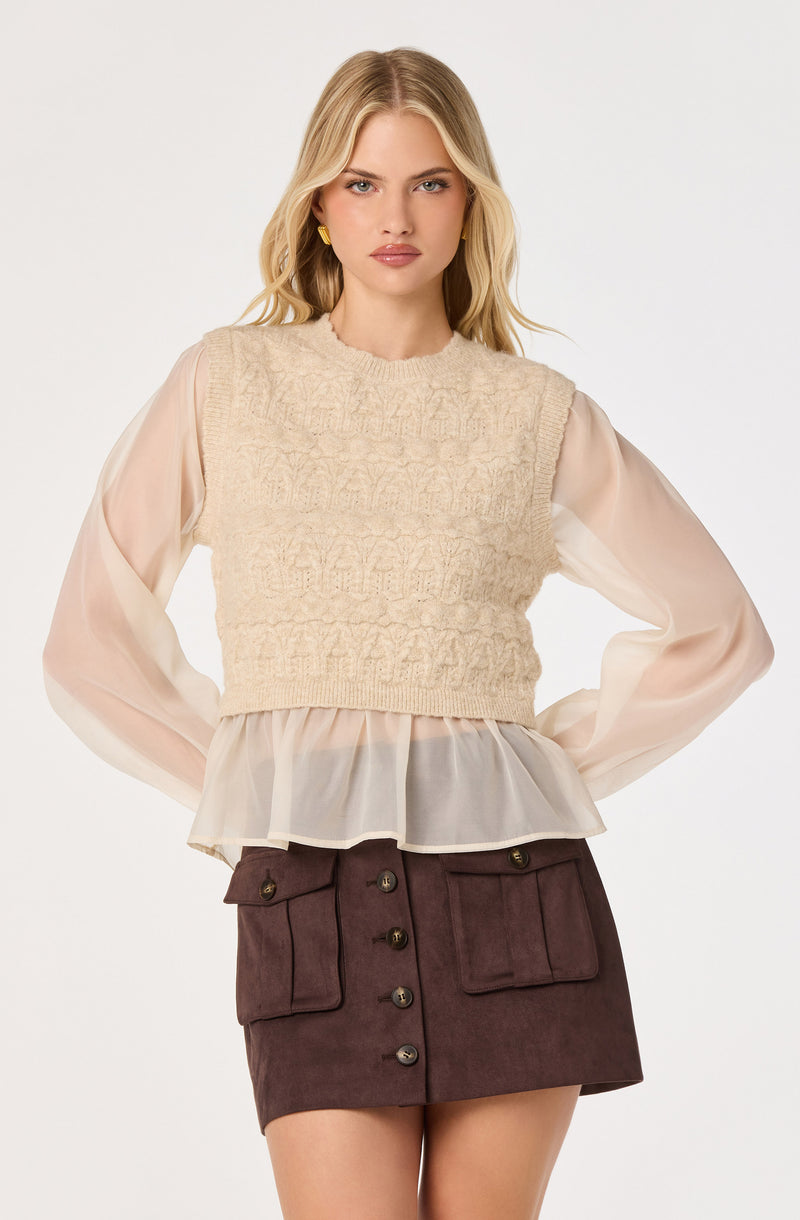 Cream textured knit vest with sheer long-sleeve blouse and maroon button-front mini skirt.