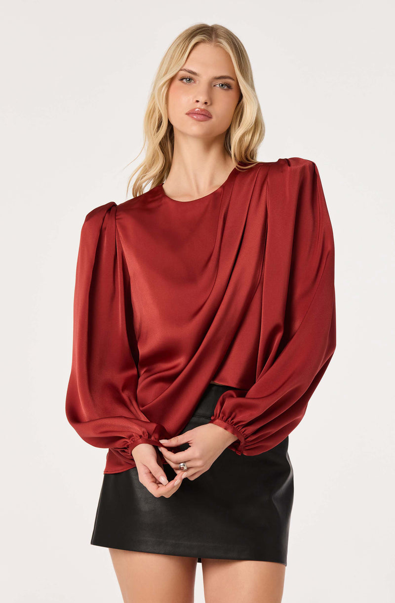 Red satin blouse with puffed long sleeves and gathered cuffs.