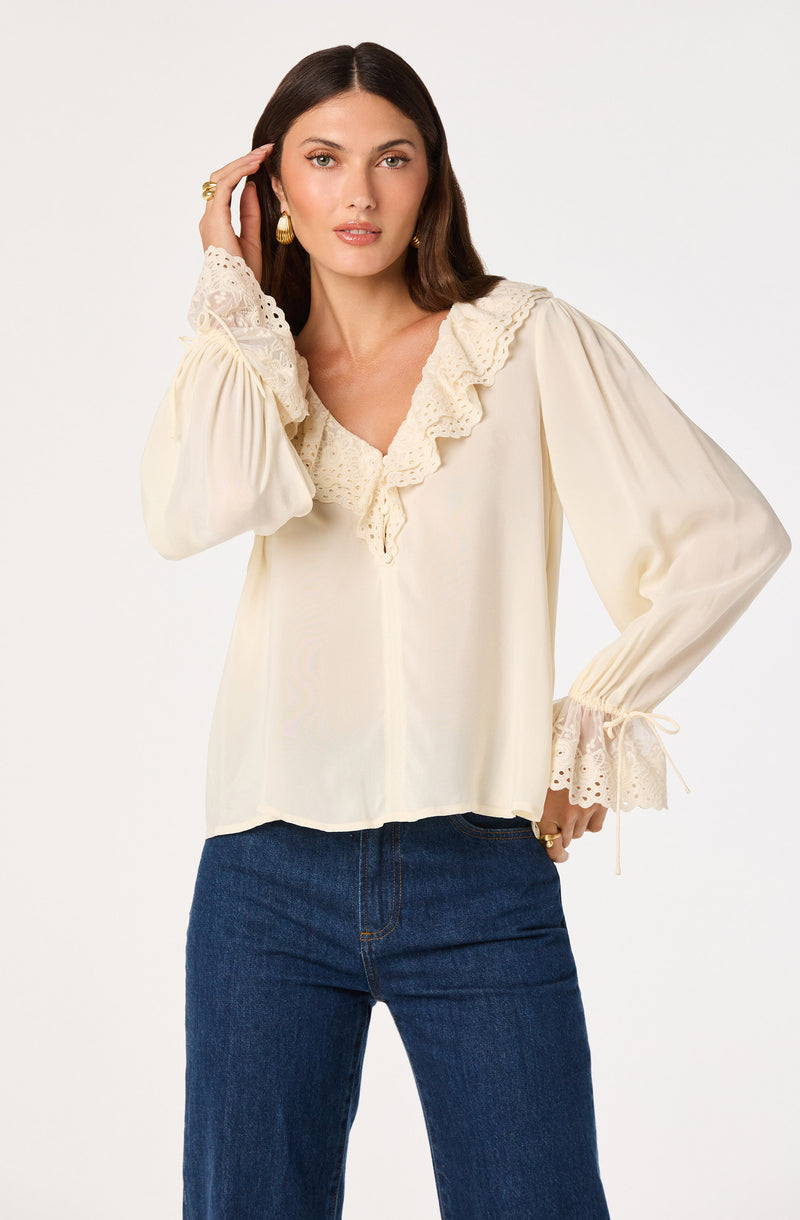 Cream long sleeve blouse with lace ruffle details on collar and cuffs.