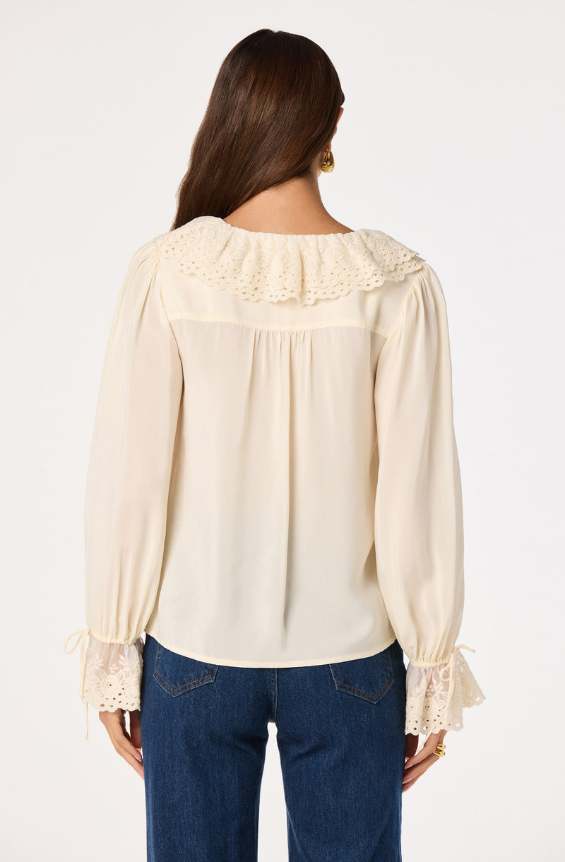 Cream blouse with embroidered lace collar and lace-trimmed cuffs, long puffed sleeves.
