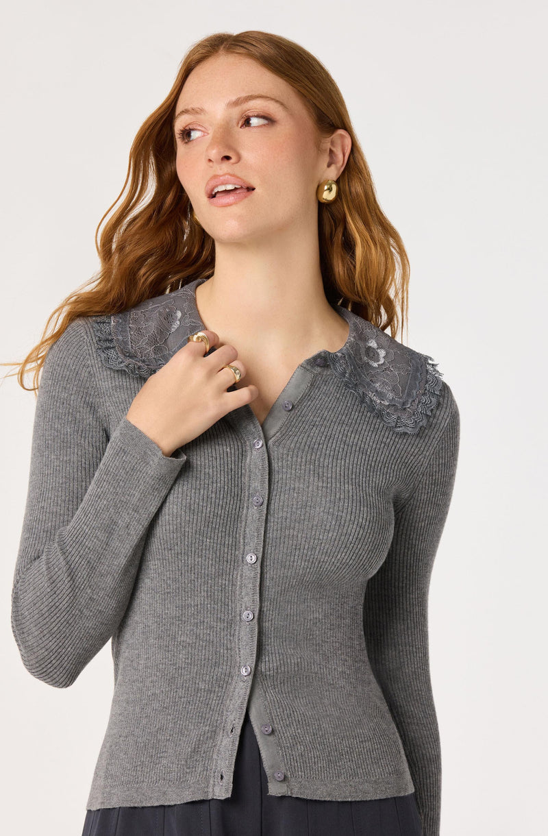 Woman wearing a fitted gray ribbed cardigan with lace shoulder details.