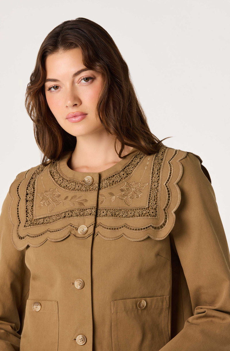 Tan jacket with embroidered floral and scalloped lace detail on the collar.