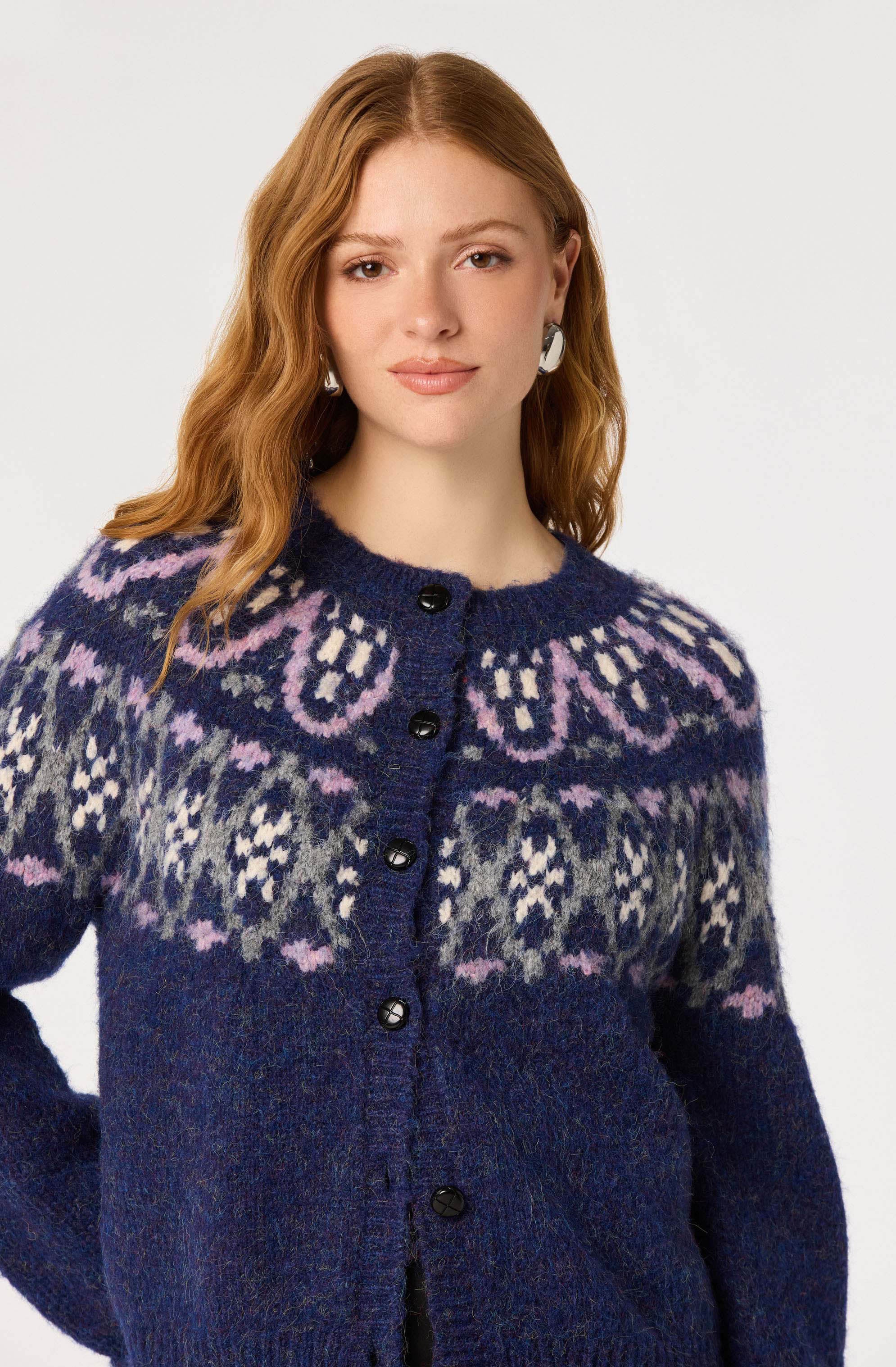 Woman wearing a navy blue sweater with pink, white, and gray Fair Isle pattern.