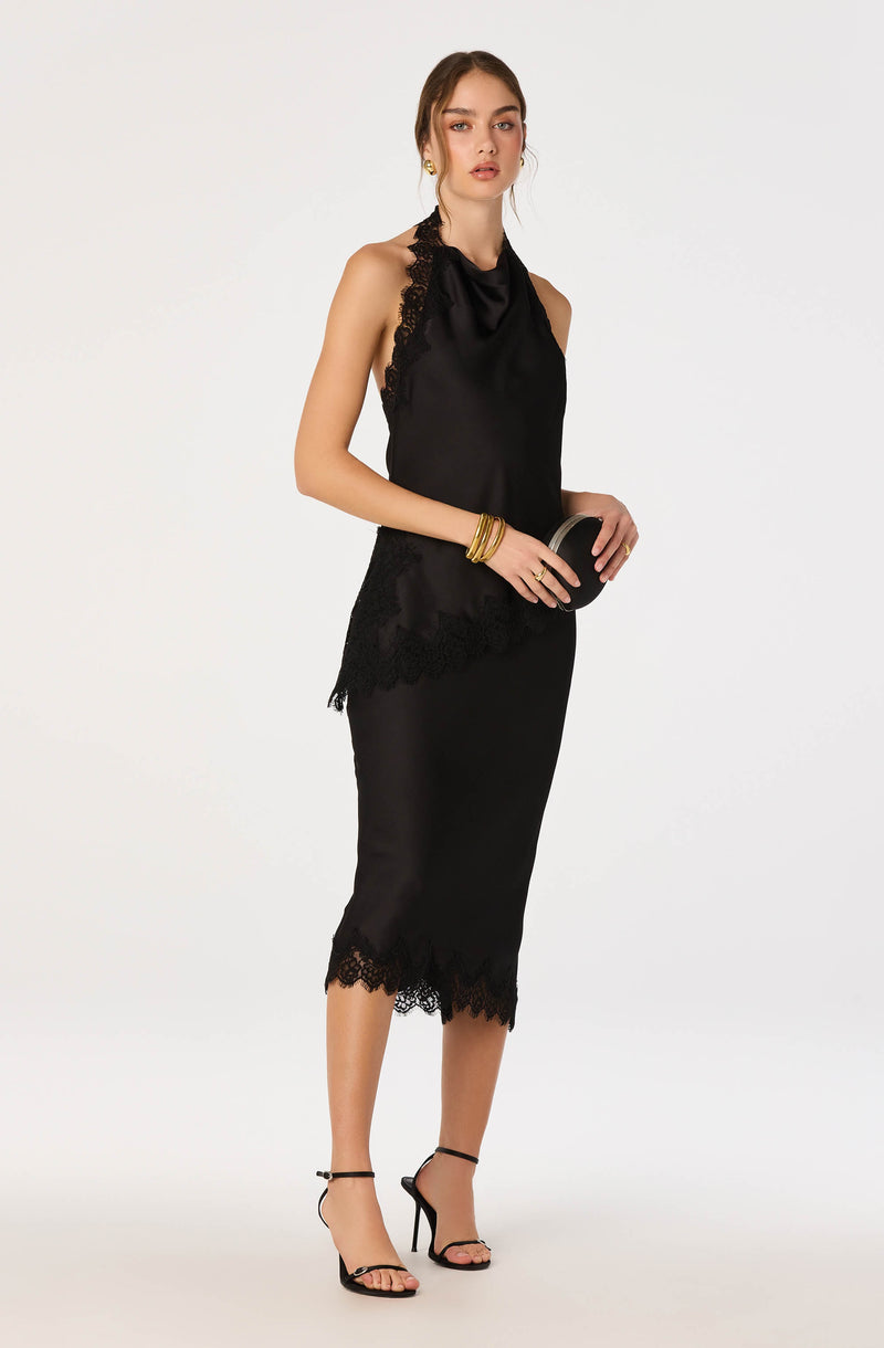 Woman in a black satin and lace sleeveless dress with a high neckline, mid-calf length, and lace trim.