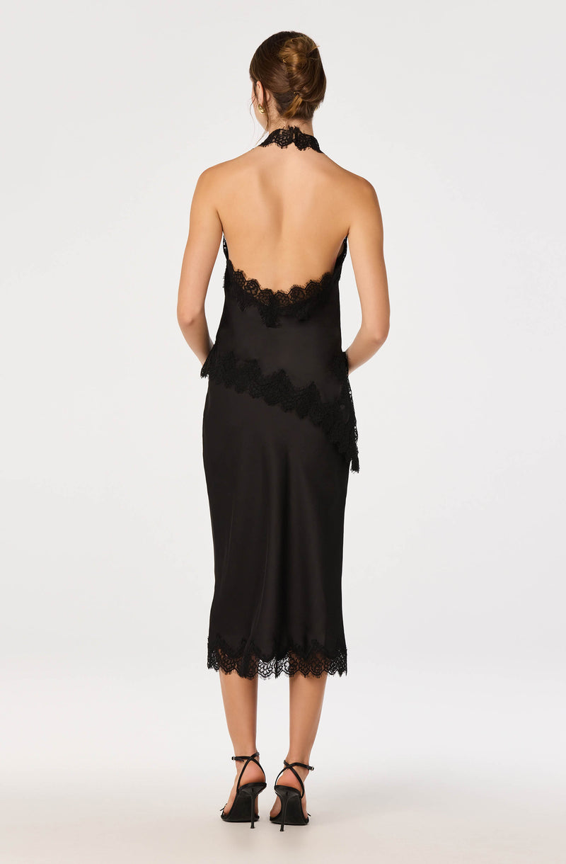 Back view of a woman in a black satin dress with lace trim, open back, and halter neckline.