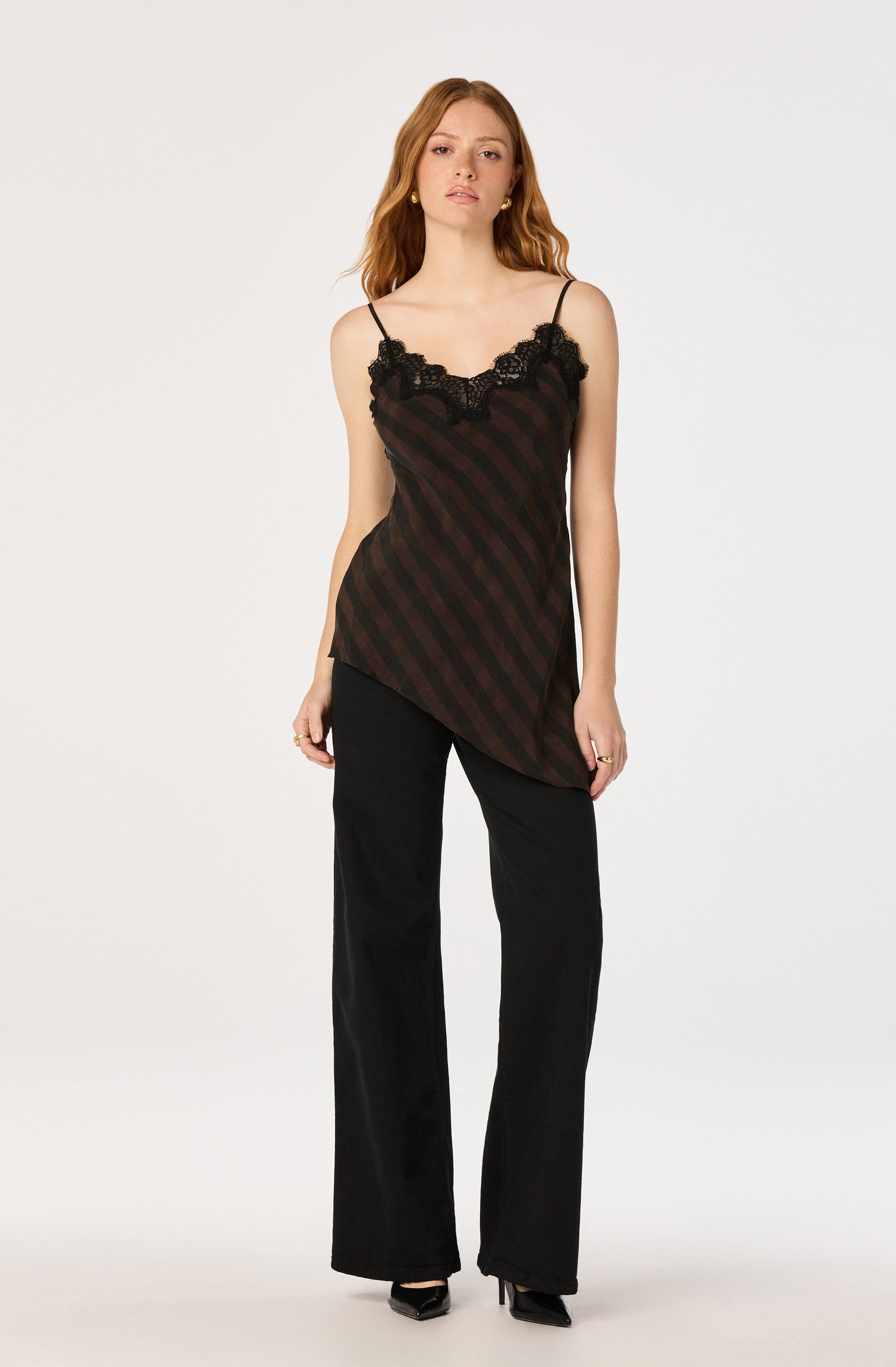 Black and brown striped satin camisole with lace trim, paired with black wide-leg pants.