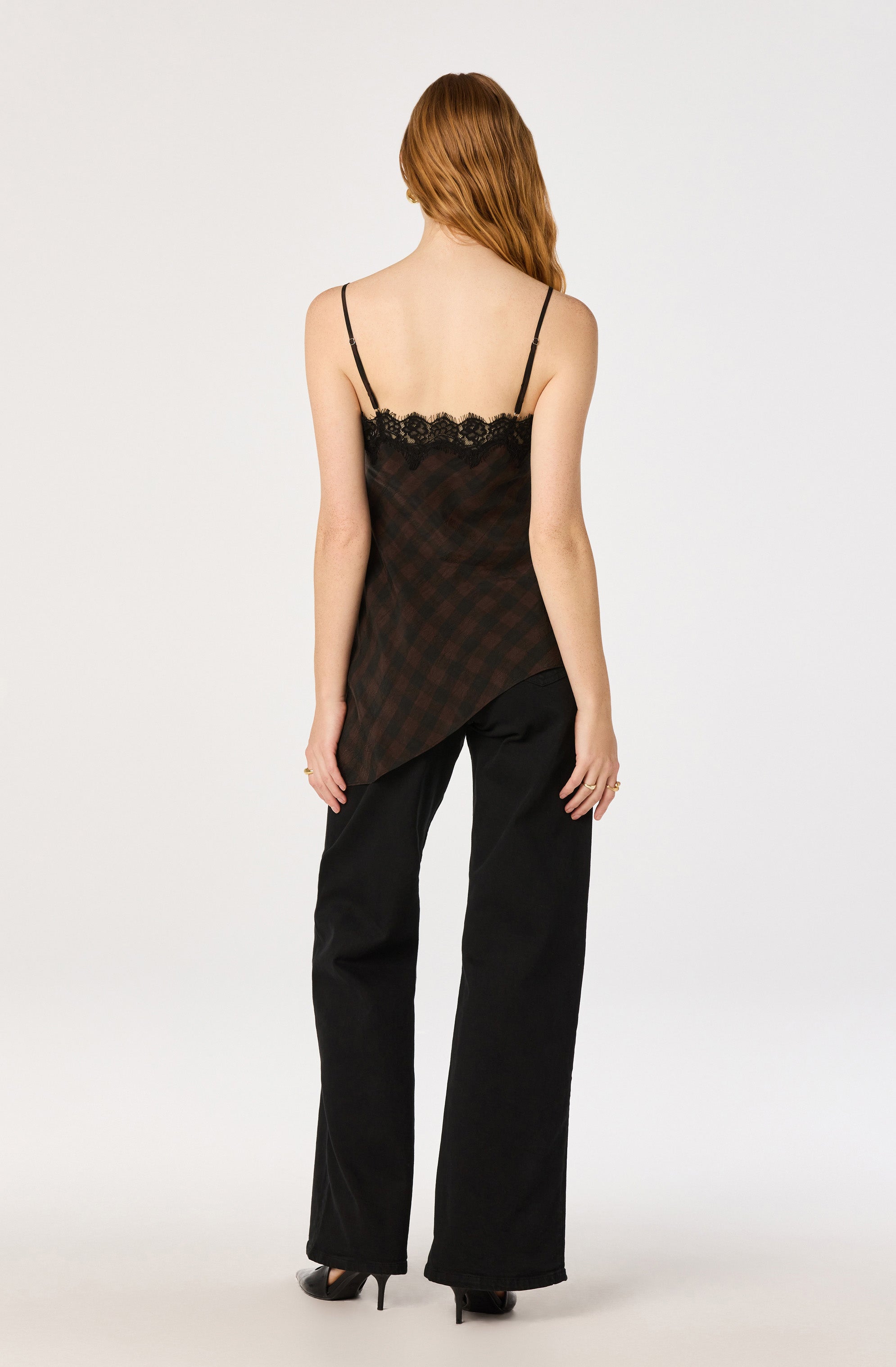 Woman wearing a black lace-trimmed, plaid camisole and black wide-leg pants.