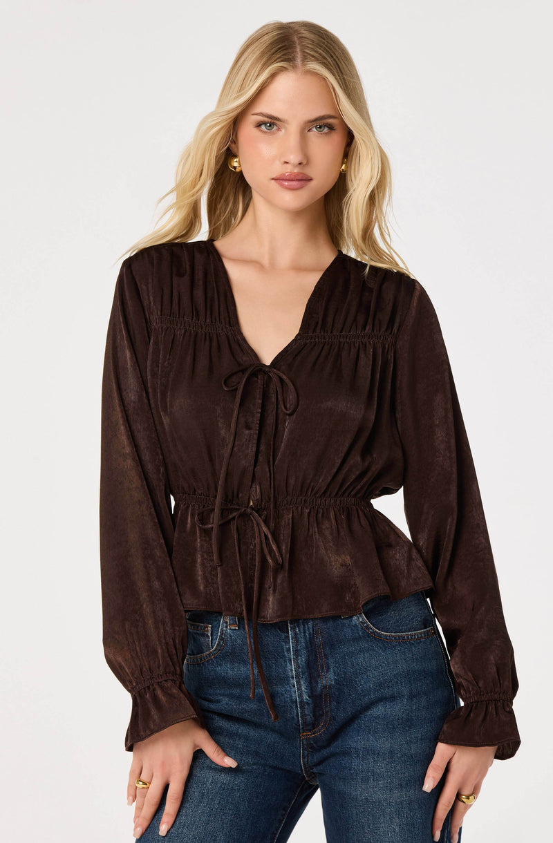 Brown velvet blouse with a tie-front, gathered shoulders, and long puffed sleeves.