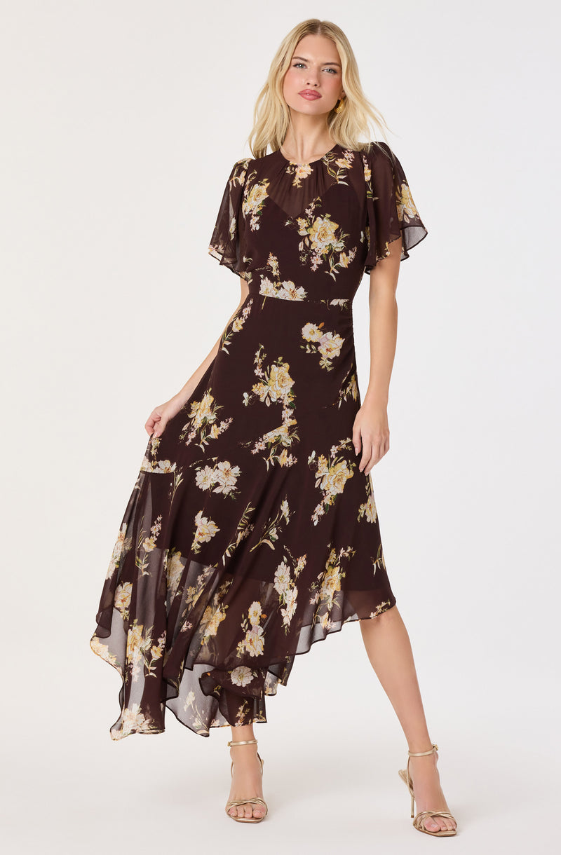 Black dress with yellow and white floral print, short flutter sleeves, and a sheer, asymmetrical hem.