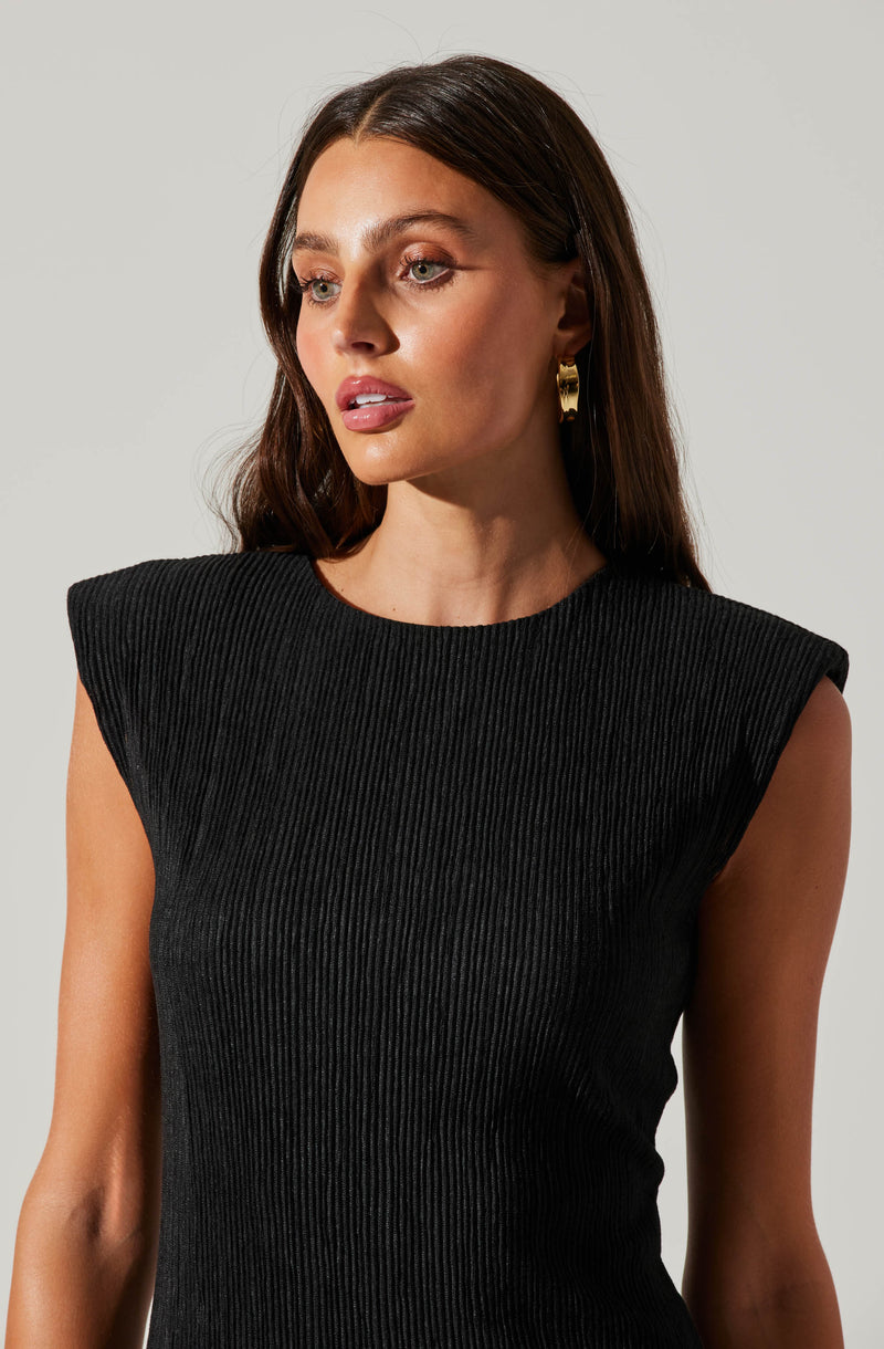 A woman wearing a black, sleeveless, ribbed top with structured, padded shoulders.