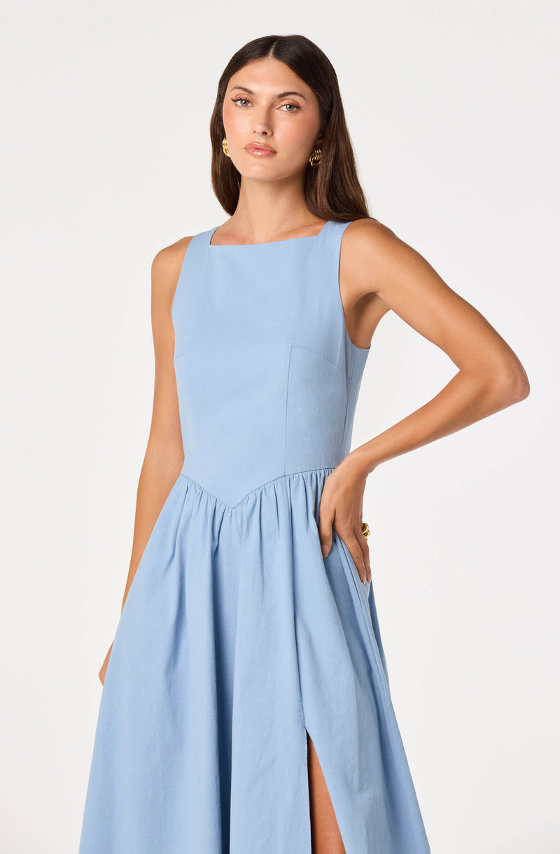 Light blue sleeveless dress with a fitted bodice and a gathered, high-slit skirt.