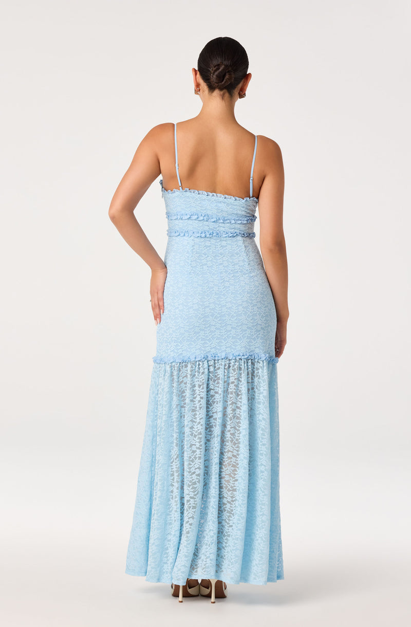 Woman in a light blue, lace, spaghetti strap dress with ruffled details from the back.