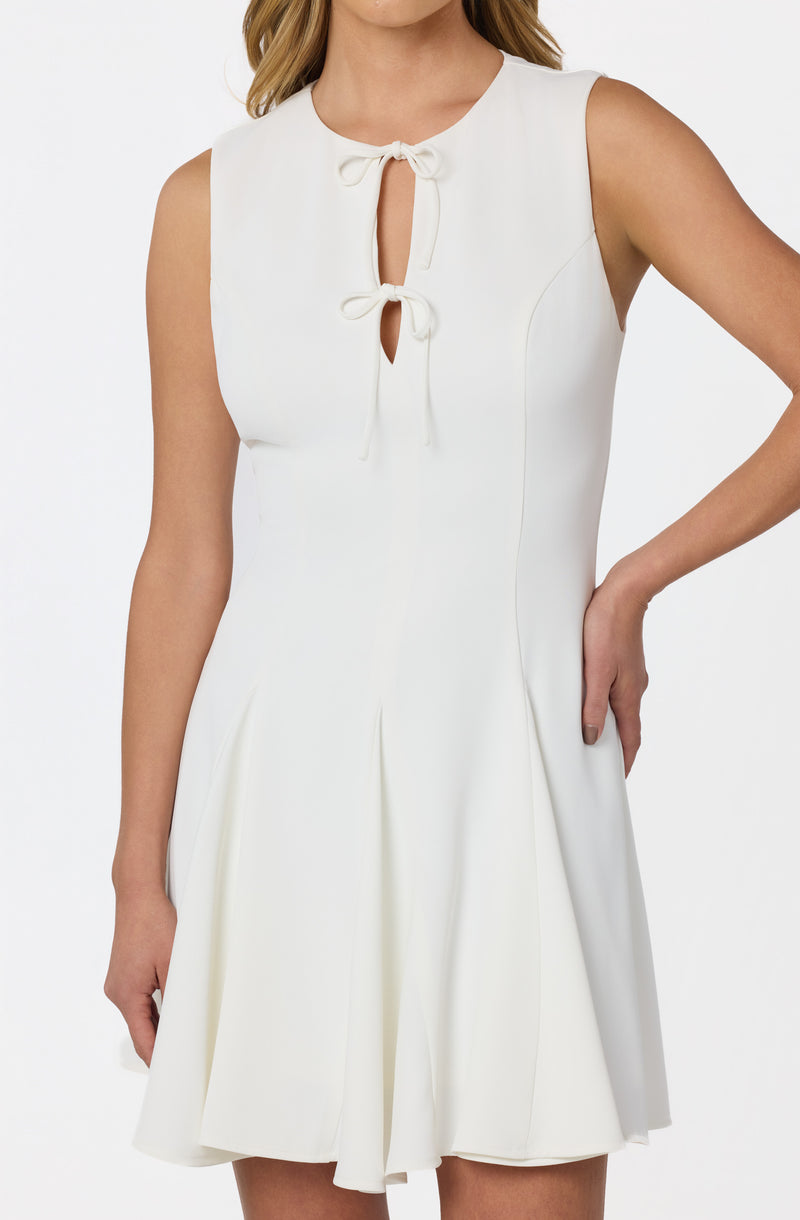 Sleeveless white dress with a keyhole neckline and two tied bows at the top.