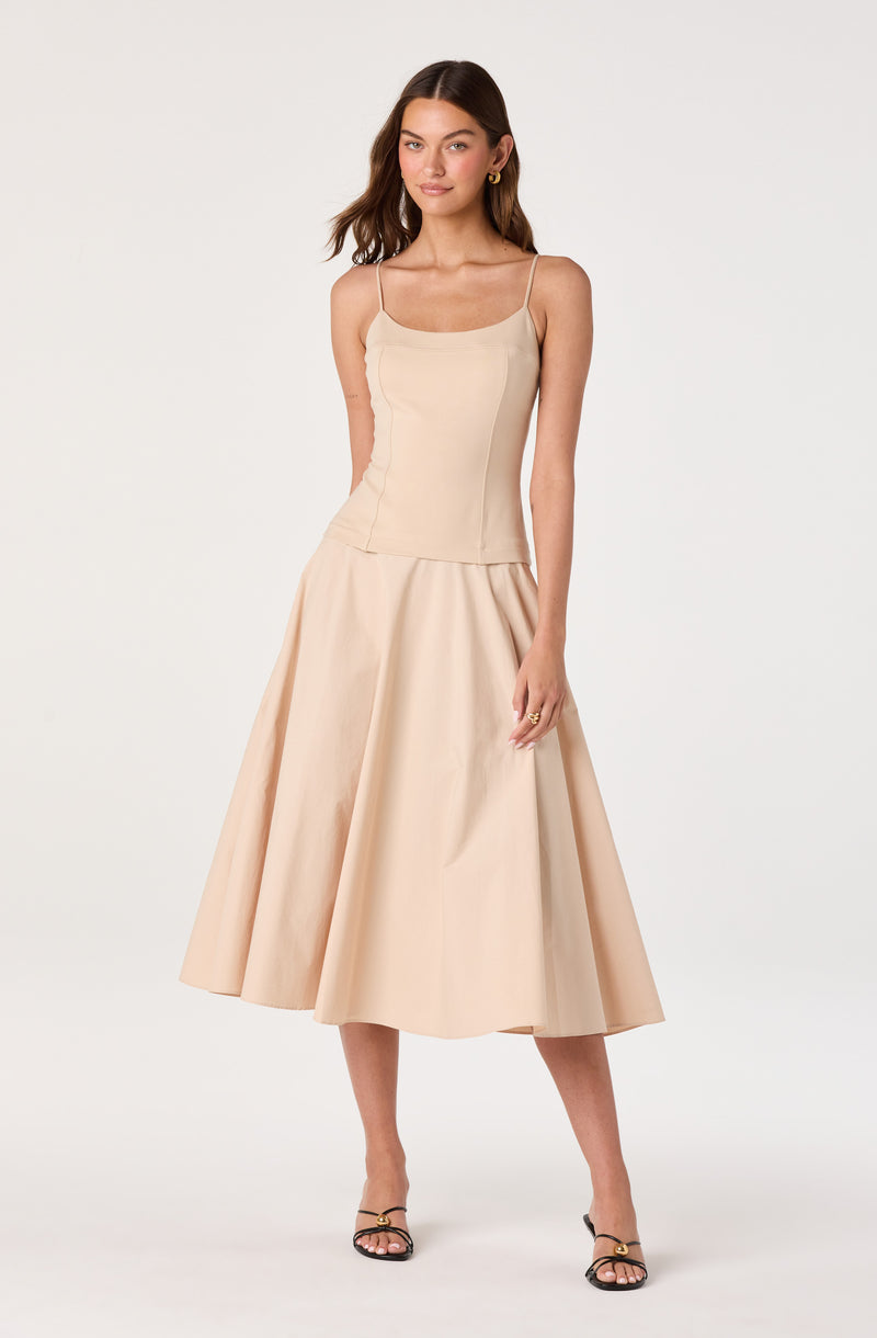 Model wearing a beige sleeveless top with thin straps and a matching beige midi skirt.