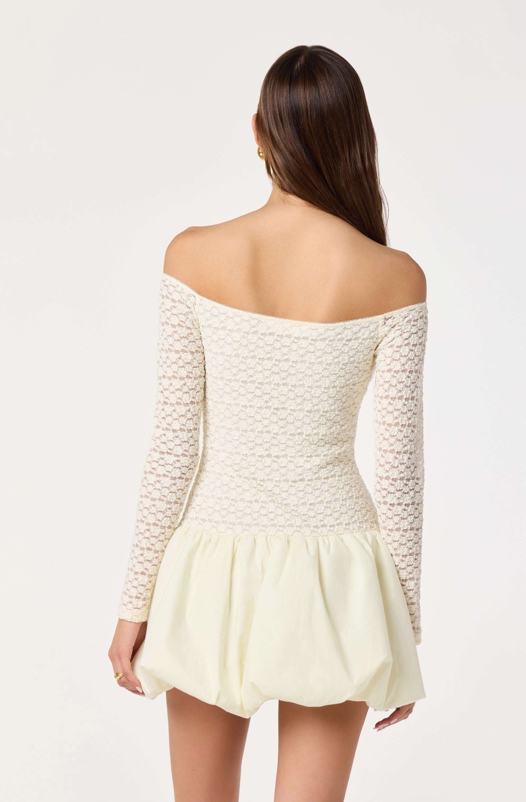 Off-shoulder cream dress with long lace sleeves and a puffed skirt.