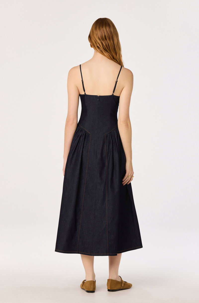 Woman in a black spaghetti strap maxi dress with brown shoes, back view.
