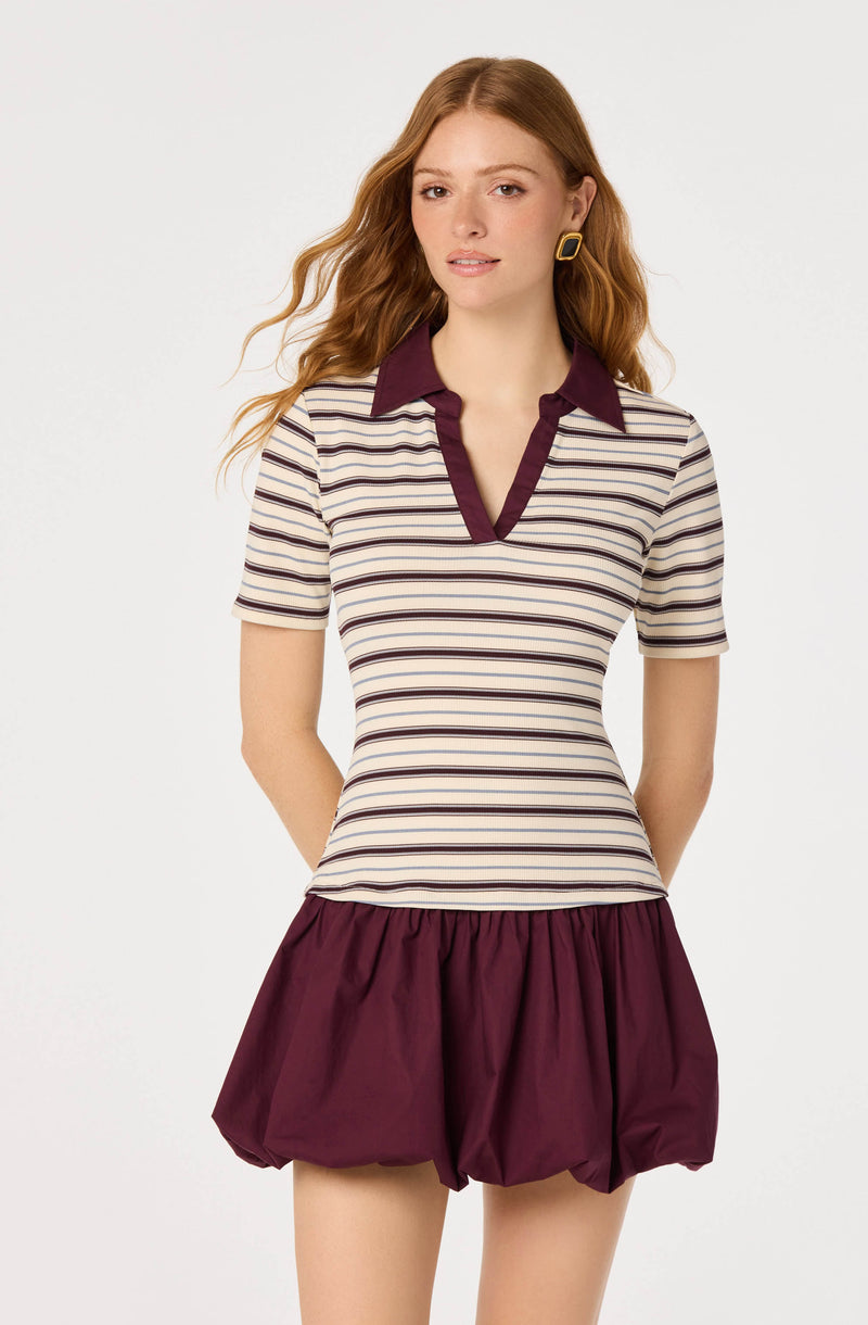 Striped beige and burgundy polo shirt with a contrasting collar and sleeve trim, paired with burgundy puffed shorts.
