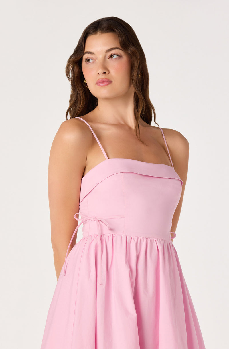 Light pink dress with thin spaghetti straps, fitted bodice, and gathered skirt.