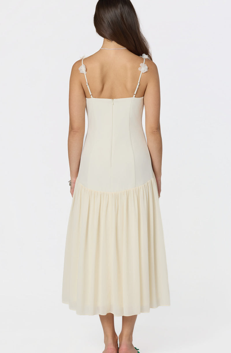 Cream-colored dress with floral shoulder straps and a pleated skirt, back view.