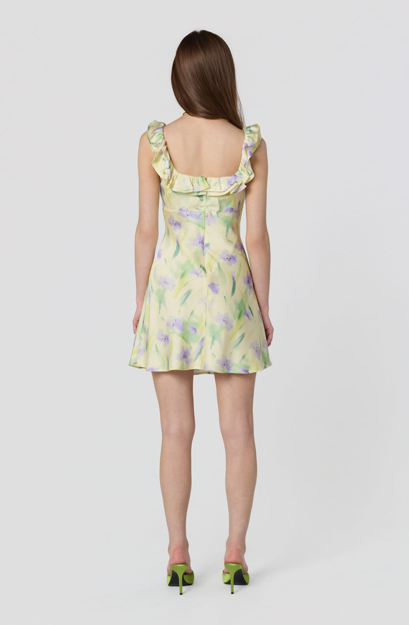 Sleeveless dress with ruffled shoulder straps, pastel yellow with purple and green watercolor-like pattern.