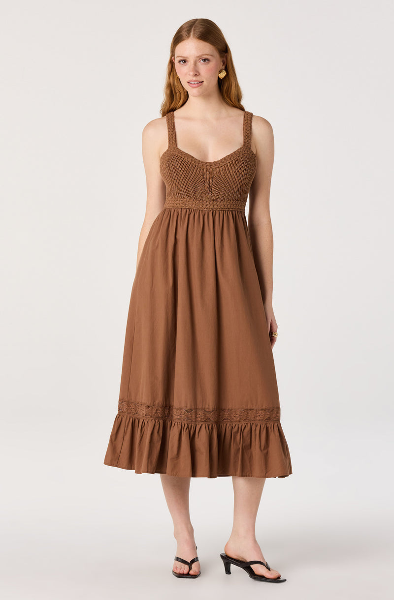 Brown sleeveless dress with thick straps, fitted knit bodice, and ruffled hem.