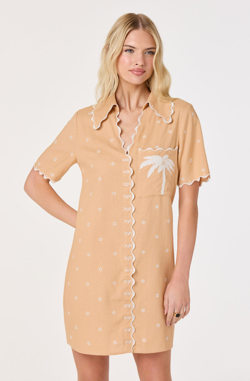 Beige shirt dress with white embroidered palm tree and small flower patterns, scalloped edges.