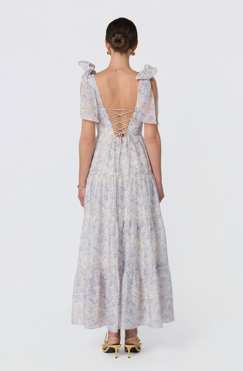 Light-colored, floral-patterned maxi dress with shoulder bows and lace-up back detail.