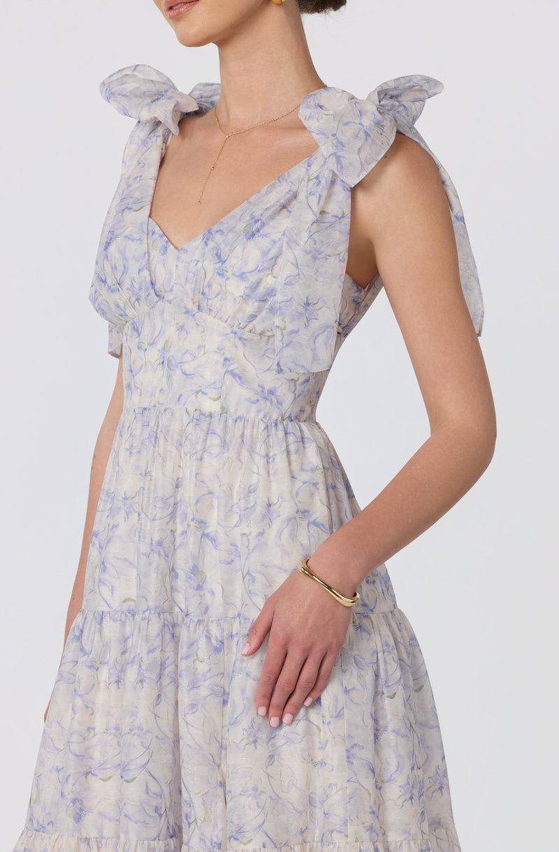 Light-colored dress with ruffled shoulder accents and a floral pattern.