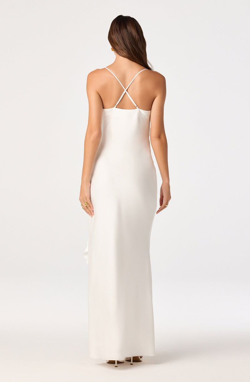Long white dress with thin, crisscross spaghetti straps and a straight, floor-length design.