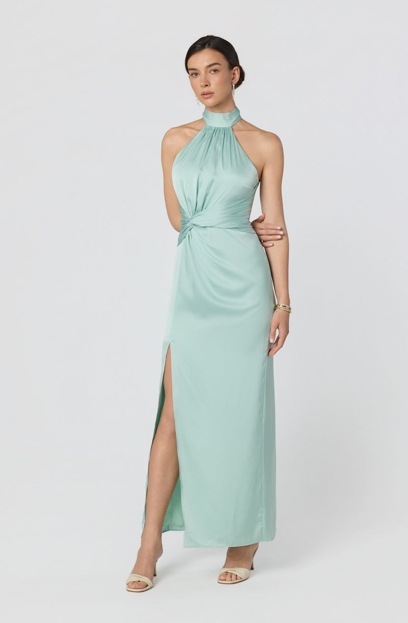 Woman in a light blue halter neck gown with gathered waist and side slit.