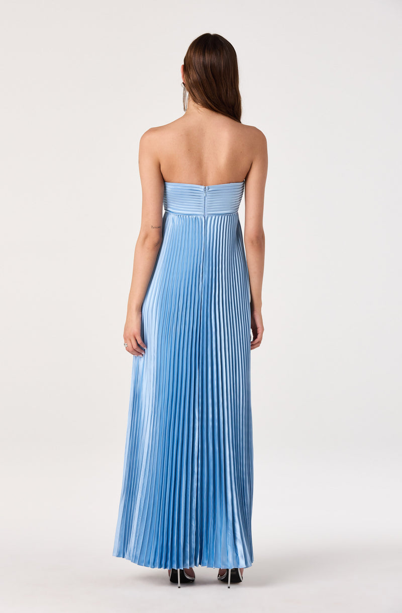 Back view of a woman wearing a strapless, pleated, ombré blue evening gown.