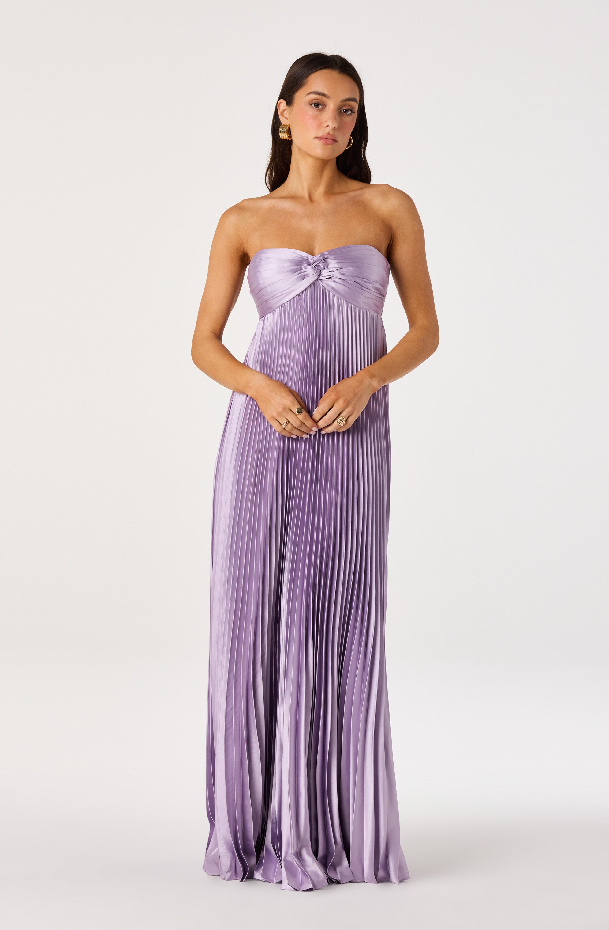 Woman in a lavender pleated strapless maxi dress with a knot detail at the bust.