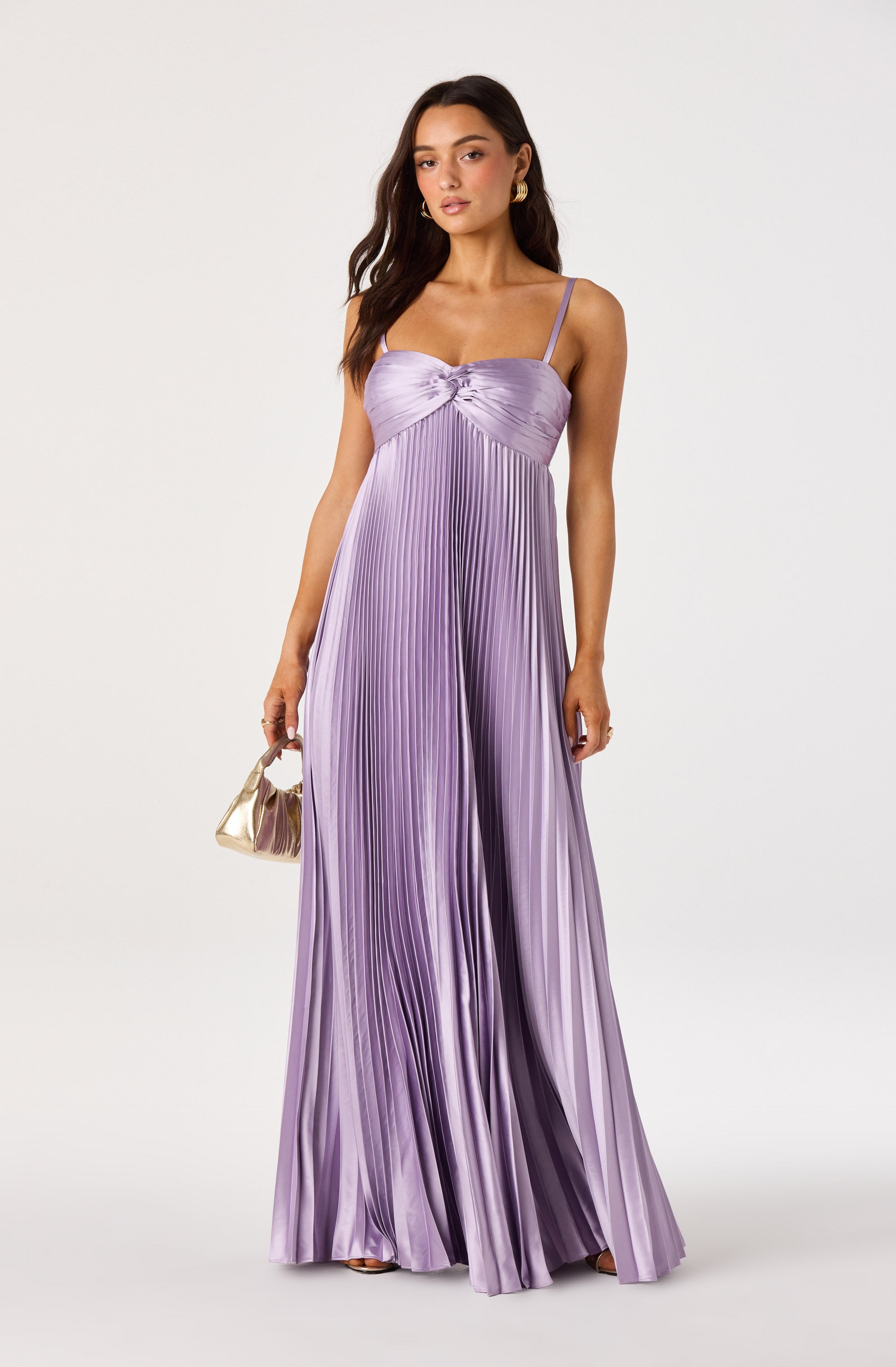 Woman wearing a long, lavender pleated satin dress with spaghetti straps.