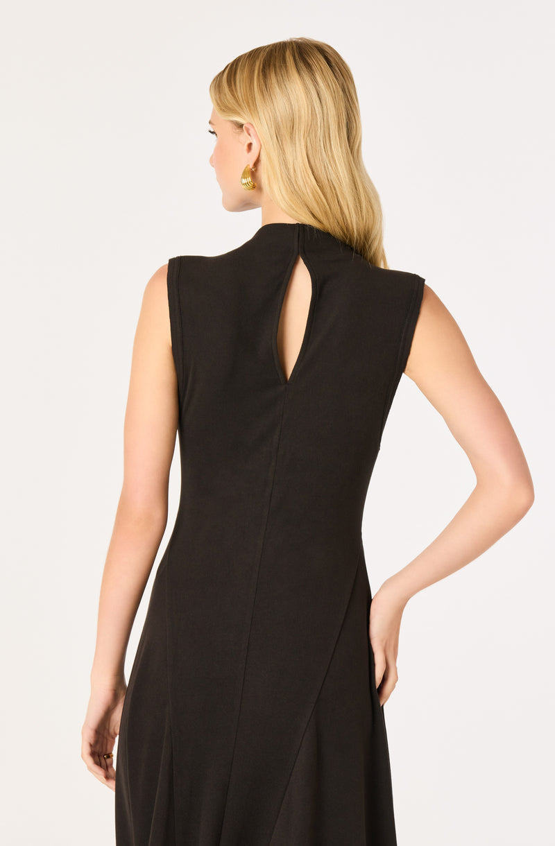 Woman wearing a sleeveless black dress with a keyhole cutout at the back.