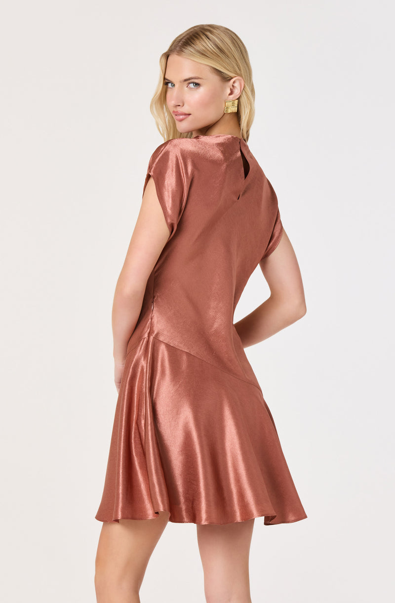 Woman in a shiny, rose-colored satin dress with short sleeves and a flared skirt.