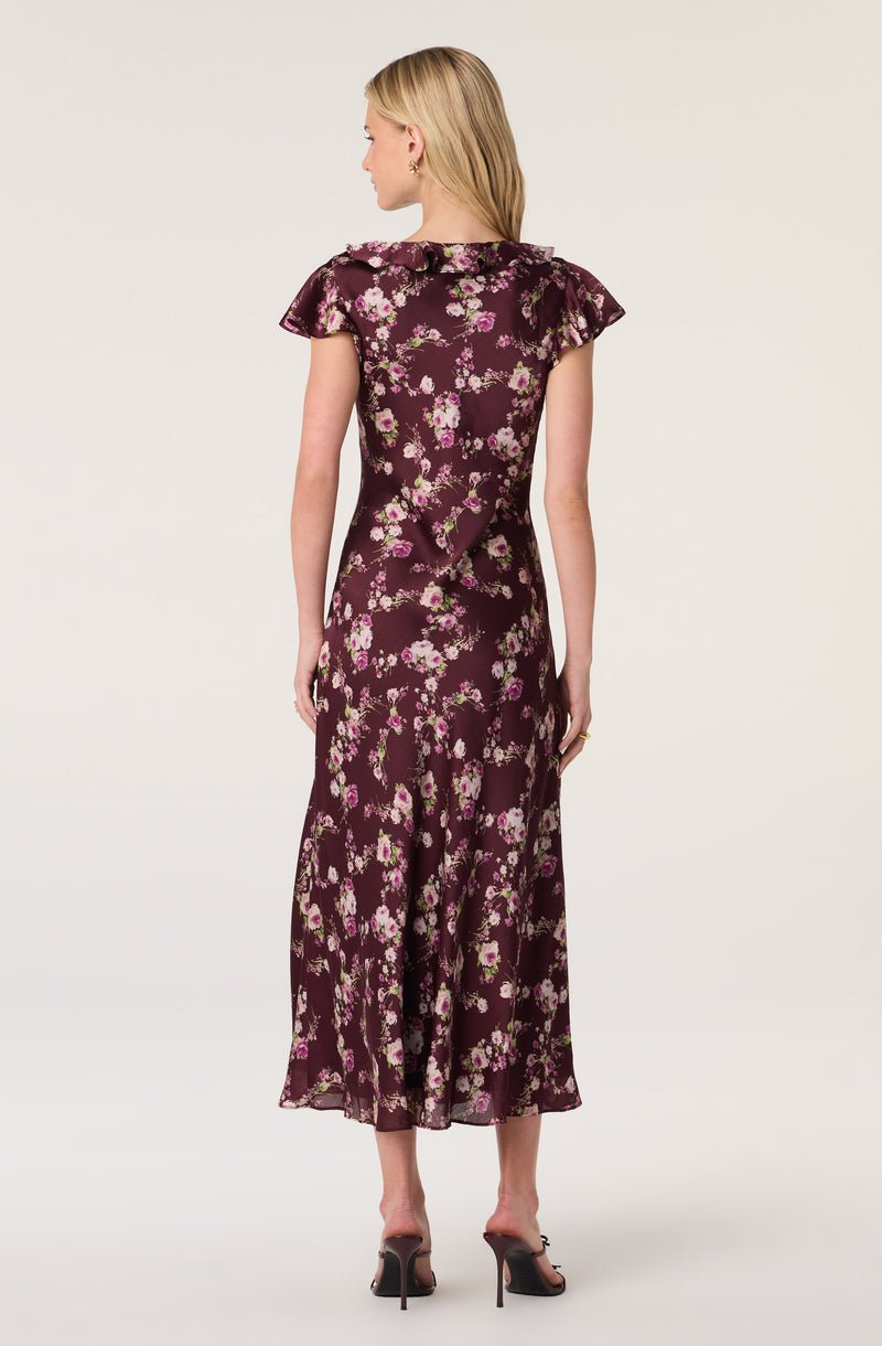 Woman's long floral dress with ruffled cap sleeves and a maroon background.