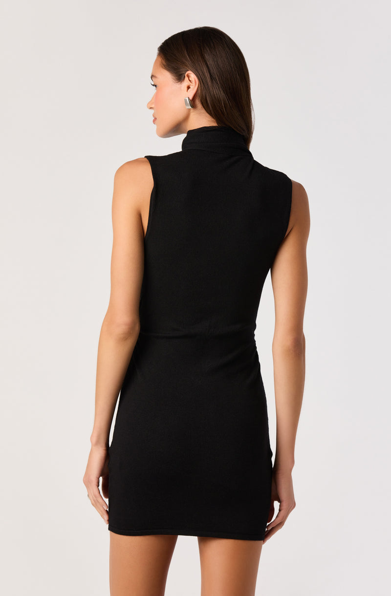 Woman in a sleeveless black turtleneck dress, facing away and looking to the side.