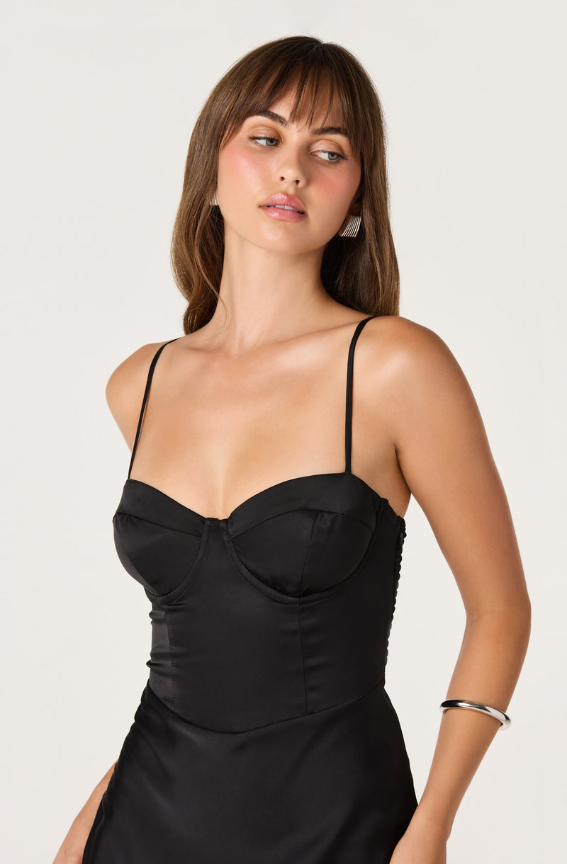 Black satin slip dress with thin spaghetti straps and a fitted bodice.